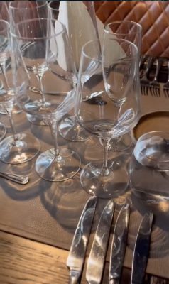 Tyylikkäästi katettu ravintolapöytä, jossa useita viinilaseja, aterimia ja nahkainen kattausalusta; kuva Ravintola Obelix Hyvinkään elegantista ja viimeistellystä ravintolamiljööstä. Elegantly set restaurant table with multiple wine glasses, cutlery and a leather placemat; image showcasing the refined dining atmosphere at Restaurant Obelix